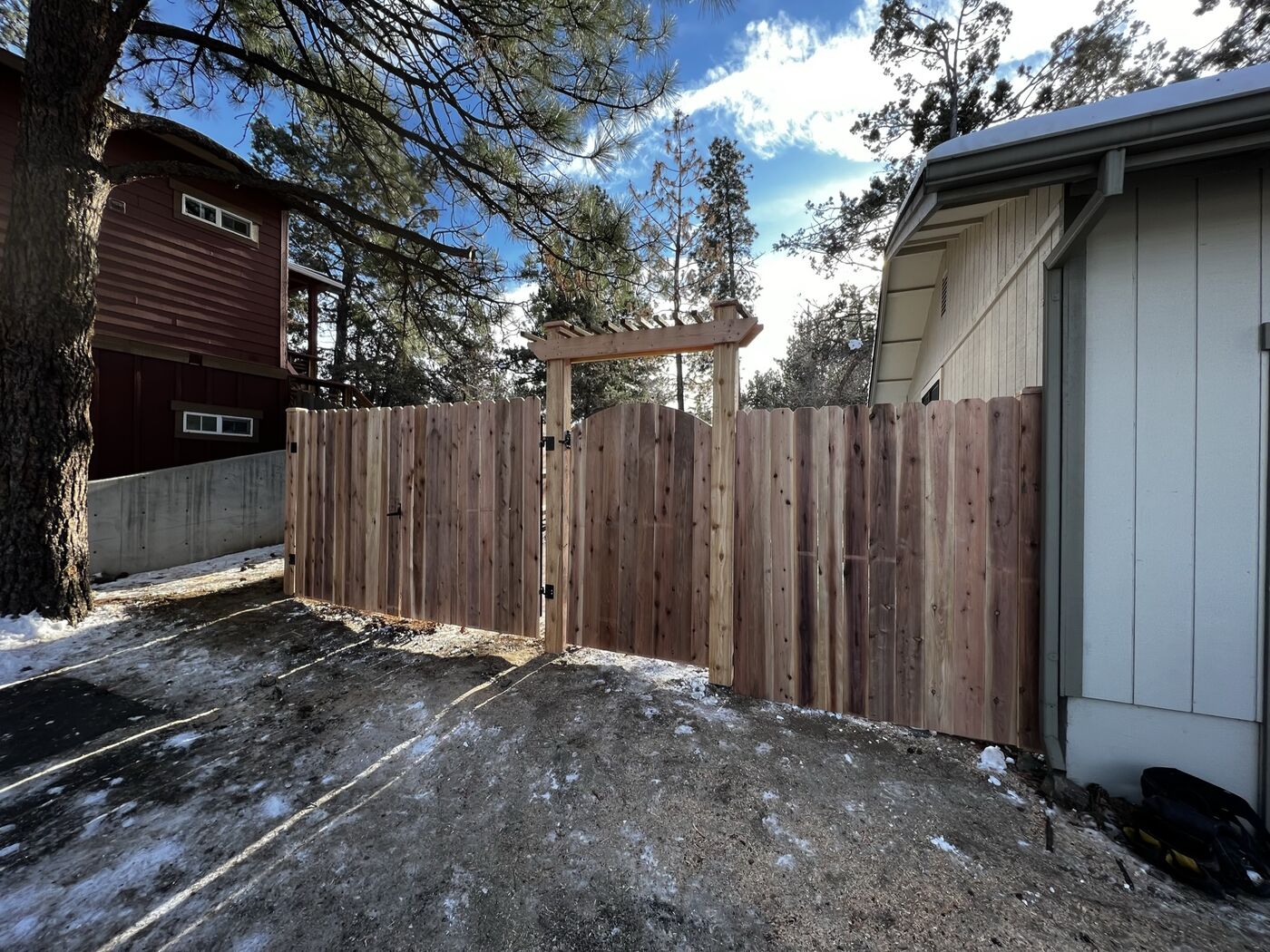 Cedar dog-ear privacy fence next to driveway